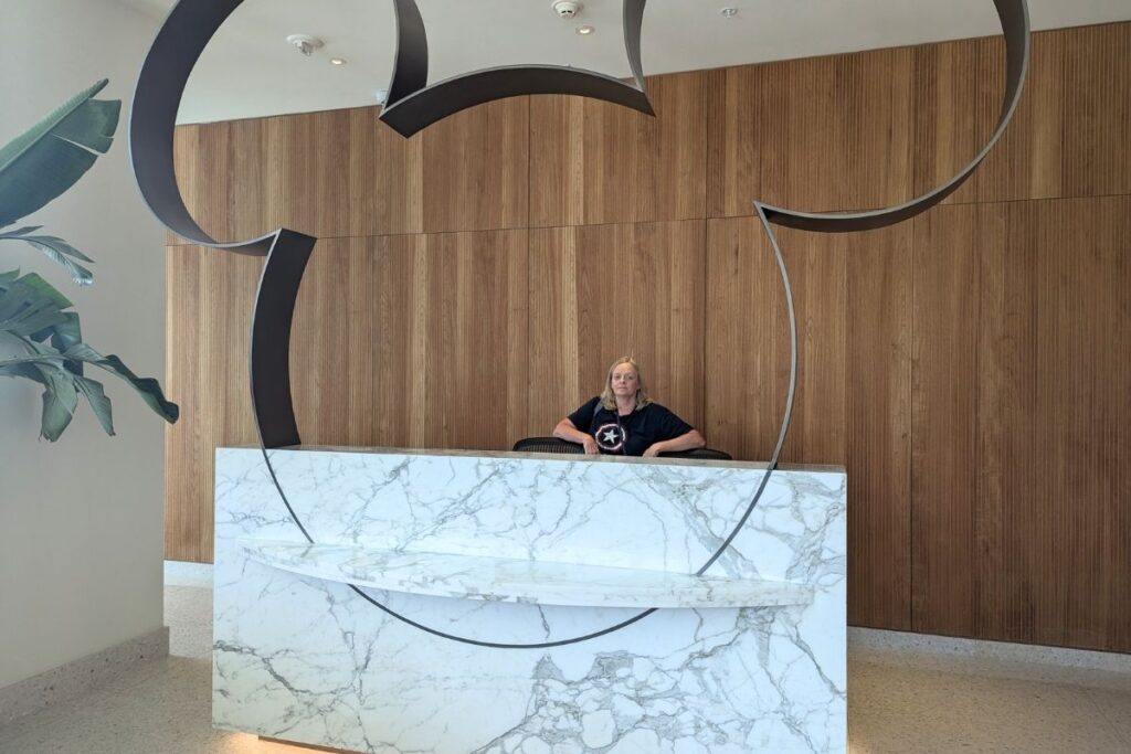 Woman behind a desk that has a metal Mickey Mouse sculpture