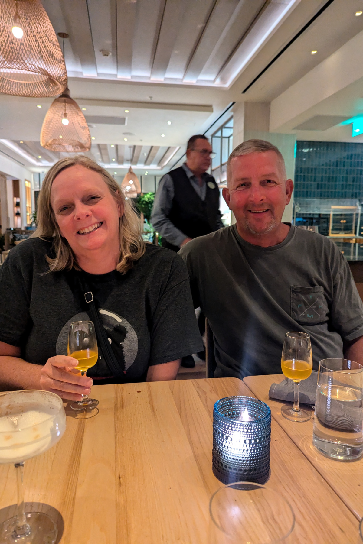 Couple at a dinner table smiling and having an after dinner cocktail